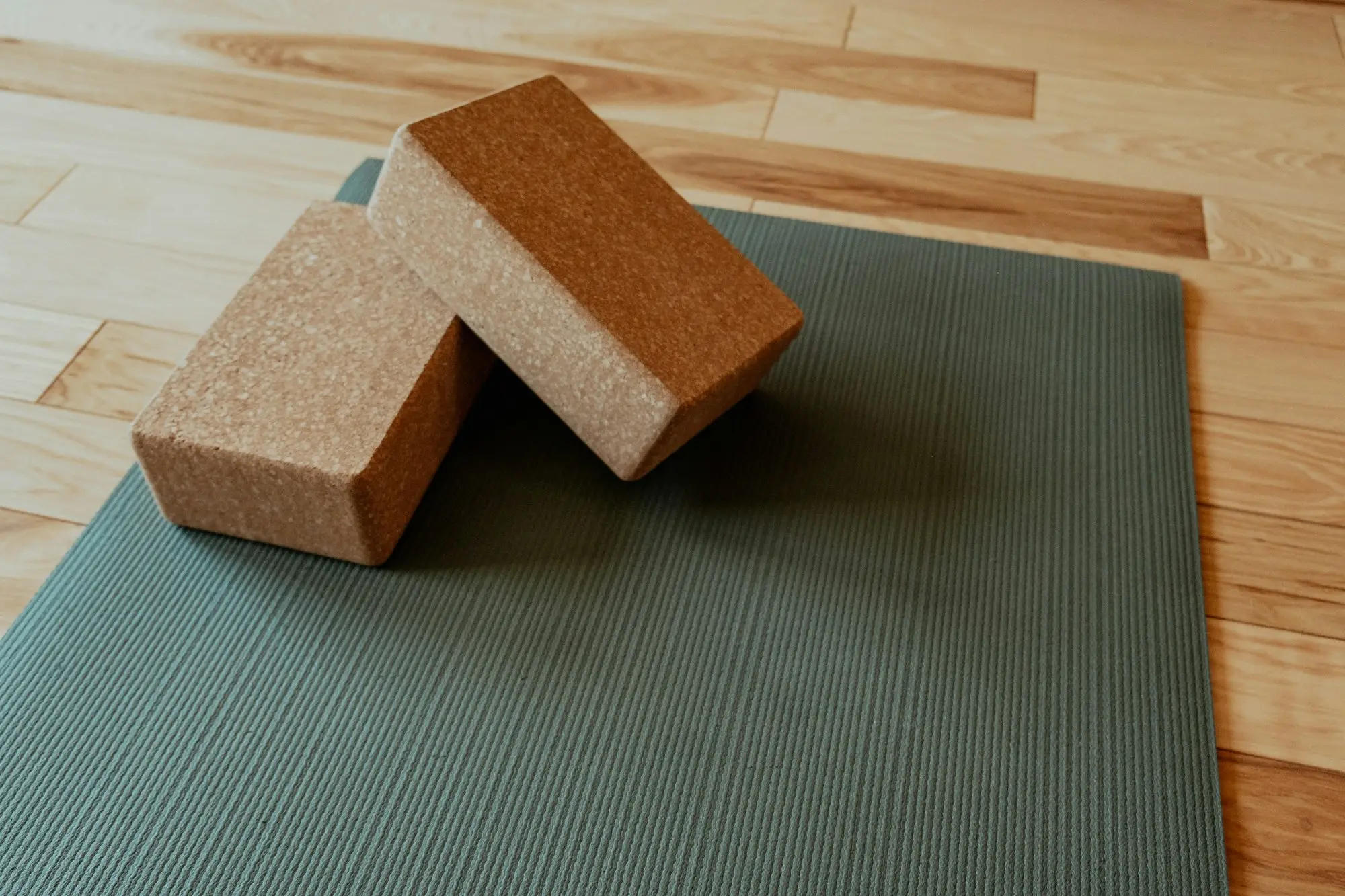 Deux blocs de yoga posés sur un tapis près d'une fenêtre lumineuse